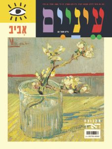vase זכוכית עם ענפים פורחים על שולחן צהוב.